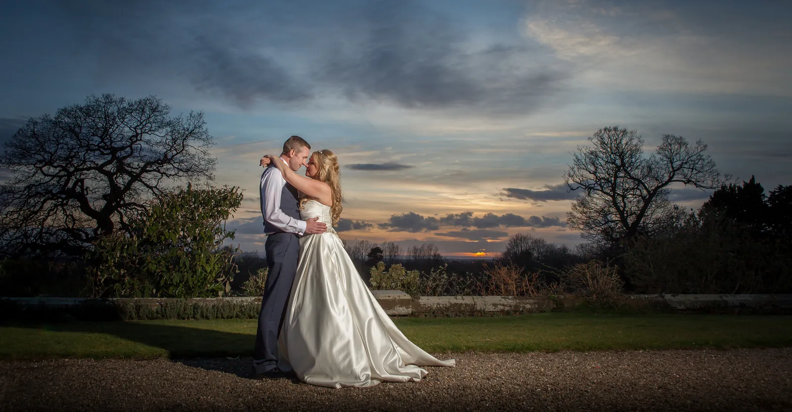 Bride and groom silhouetted against a spring sunset at Willington Hall, Cheshire