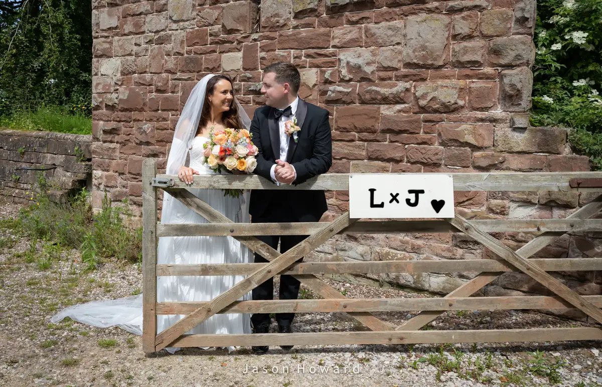 Bride and groom by the gates at their Rowton Hall Hotel wedding, Chester