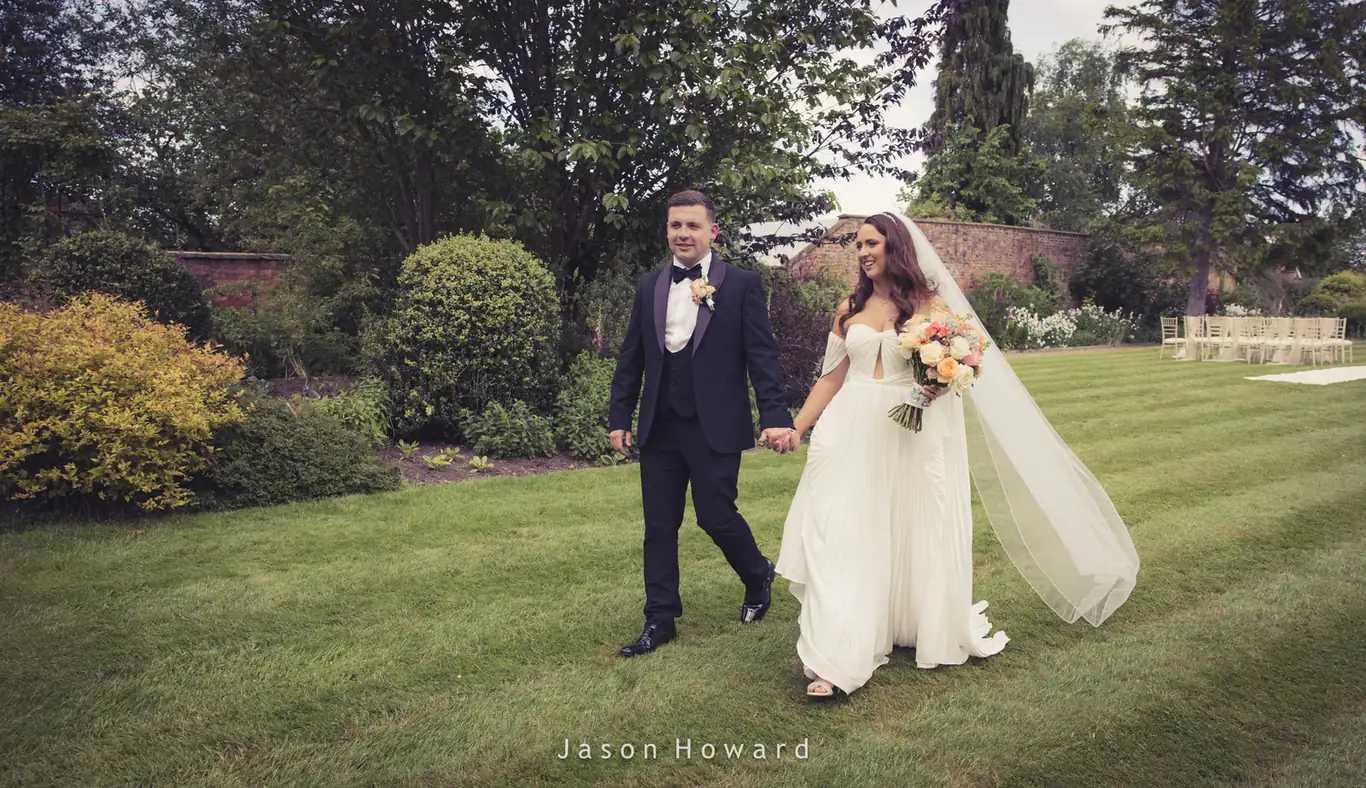 Newlyweds together in the garden at Rowton Hall Hotel, Chester