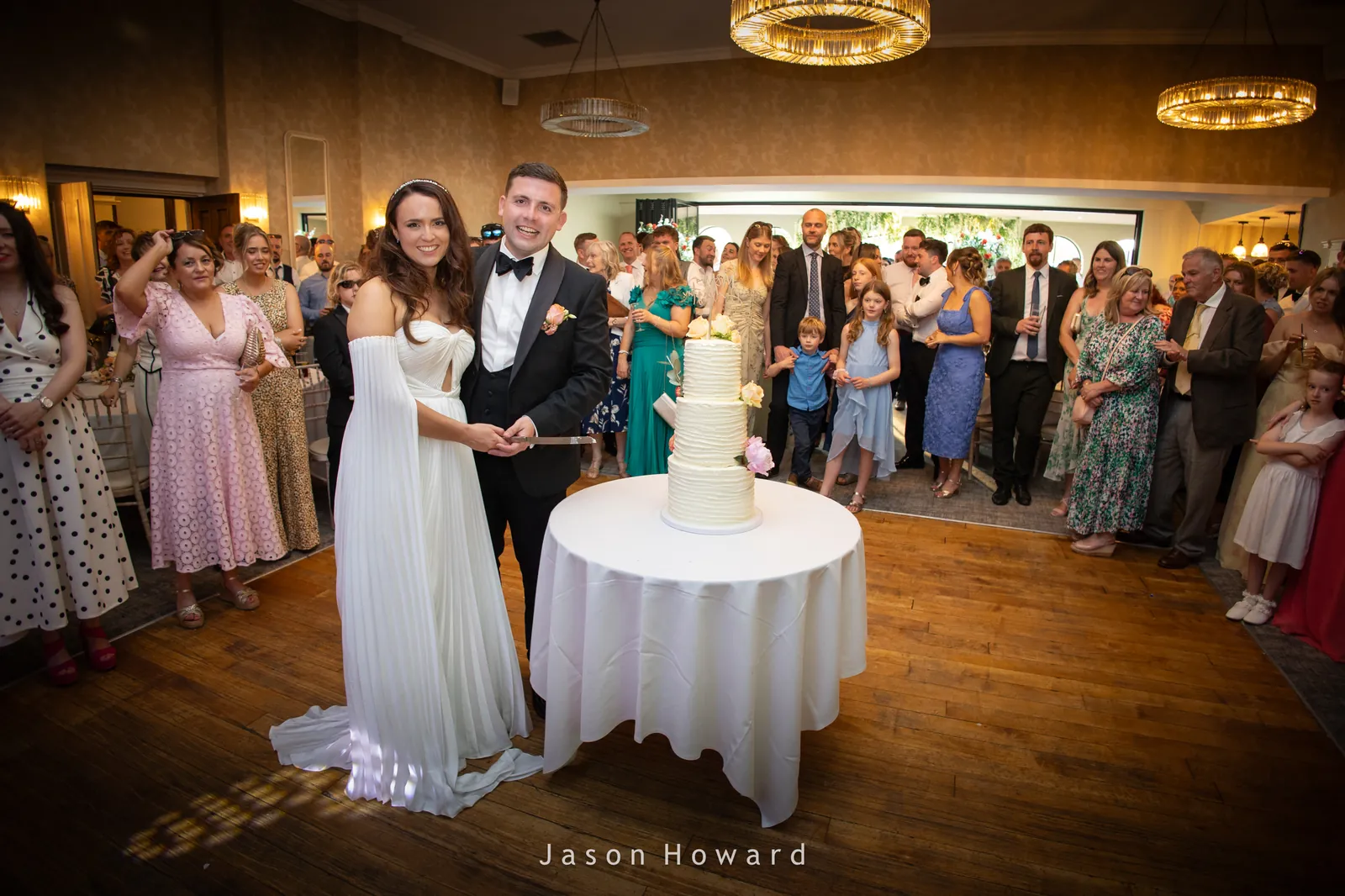 Cutting the cake at a Rowton Hall Hotel wedding, Chester