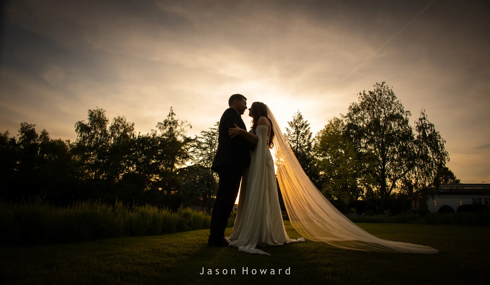 Sunset silhouette of the bride and groom at Rowton Hall Hotel, Chester